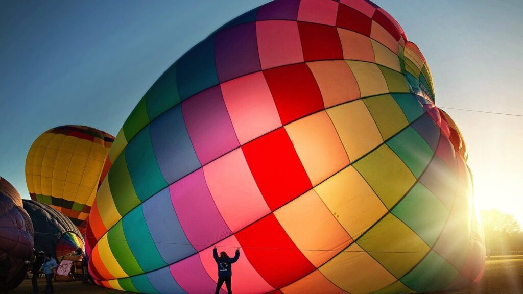 Ein bunter Heißluftballon startet im Morgengrauen